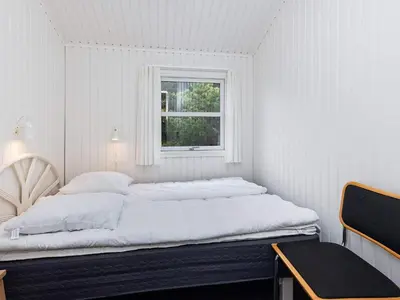 a white bedroom with a bed and a window at Luxury Retreat near Beach - By Traum Ferienwohnungen in Blokhus
