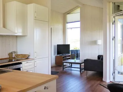 a kitchen and living room with a couch and a table at 6 person holiday home in Lemvig-By Traum in Trans