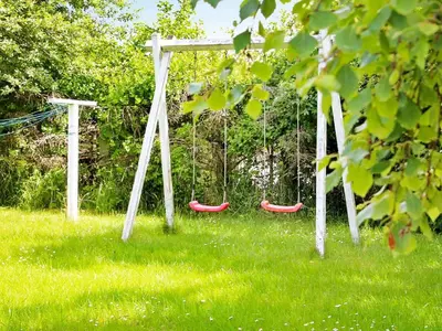 two swings in a field with green grass at 8 person holiday home in Fjerritslev-By Traum in Slettestrand