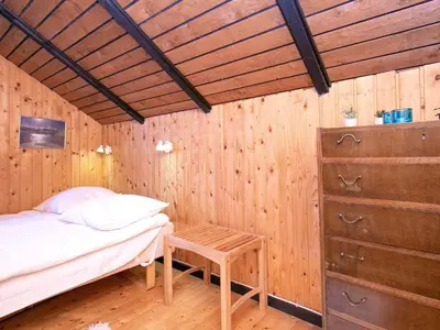 a bedroom with a bed and a wooden wall at Seaside Rustic Retreat - By Traum Ferienwohnungen in Flovtrup