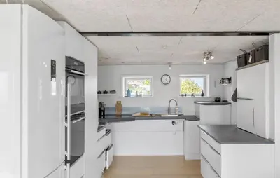 a kitchen with white cabinets and a sink at Cozy Home In Øster Assels With Wifi in Øster Assels