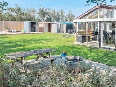 a backyard with a wooden picnic table and a garden at 12 person holiday home in Vinderup-By Traum in Vinderup