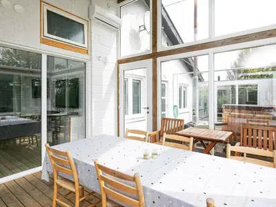 a porch with a white table and chairs and windows at 12 person holiday home in Vinderup-By Traum in Vinderup