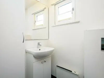 a white bathroom with a sink and a mirror at 12 person holiday home in Vinderup-By Traum in Vinderup