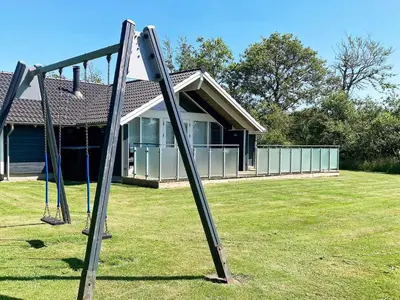 a pair of swings in front of a house at 6 person holiday home in Vinderup-By Traum in Vinderup