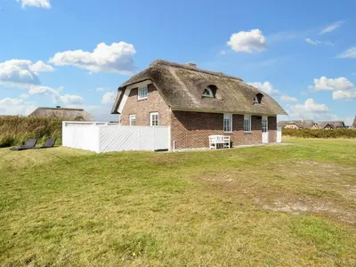 a house with a thatched roof on a field at 9 person holiday home in Harboøre-By Traum in Harboør