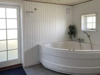 a large white tub in a bathroom with a window at 9 person holiday home in Harboøre-By Traum in Harboør