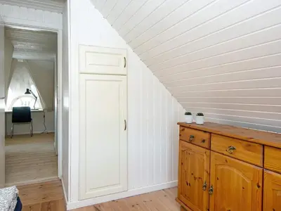 an attic room with a white ceiling and a wooden dresser at 9 person holiday home in Harboøre-By Traum in Harboør