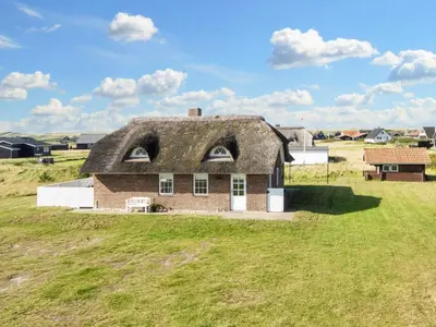 an old house with a thatched roof on a field at 9 person holiday home in Harboøre-By Traum in Harboør