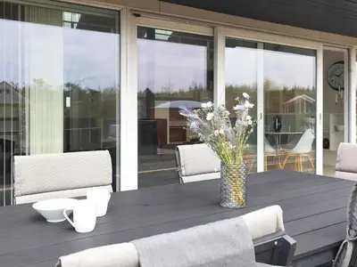 a wooden table with a vase of flowers on it at 8 person holiday home in Brovst-By Traum in Brovst