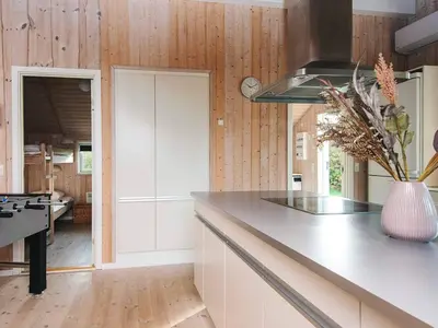 a kitchen with wooden walls and a counter with a vase at 8 person holiday home in Harboøre-By Traum in Harboør
