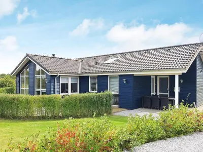a blue house with a yard at 8 person holiday home in Skals in Hjarbæk