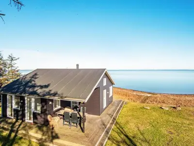a house with a metal roof and a view of the water at 6 person holiday home in Harboøre-By Traum in Harboør