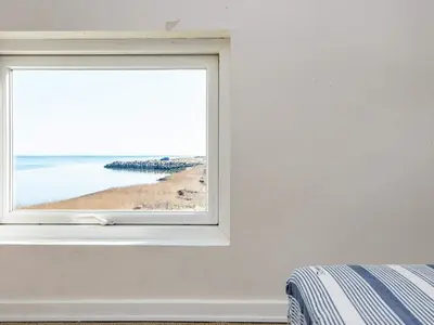 a window in a bedroom with a view of the beach at 6 person holiday home in Harboøre-By Traum in Harboør