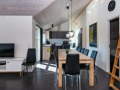 a dining room and kitchen with a wooden table and chairs at 10 person holiday home in Løgstør-By Traum in Trend