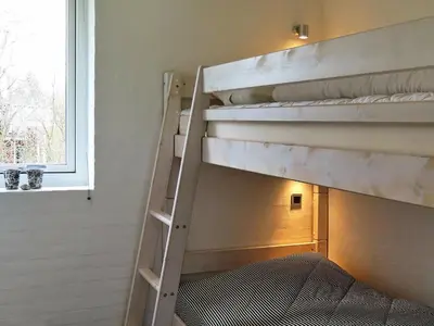 a bunk bed in a room with a ladder at 6 person holiday home in Struer-By Traum in Remmer Strand