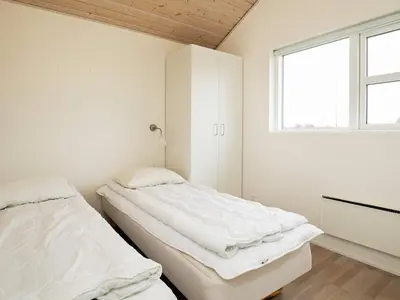 two beds in a white room with a window at 8 person holiday home in Brovst-By Traum in Brovst