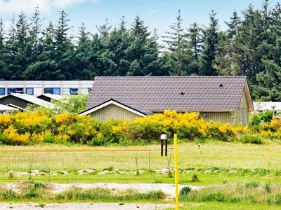 a house in a field next to a building at 8 person holiday home in Brovst-By Traum in Brovst