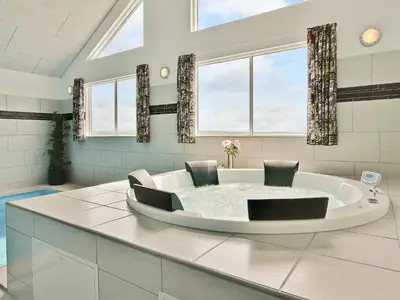 a large bathroom with a tub with two chairs at Luxury Retreat by the Sea - By Traum Ferienwohnungen in Harboør
