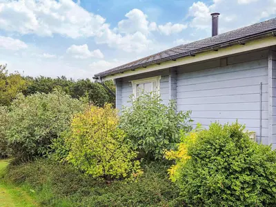 a white house with bushes in front of it at 6 person holiday home in Roslev-By Traum in Flovtrup