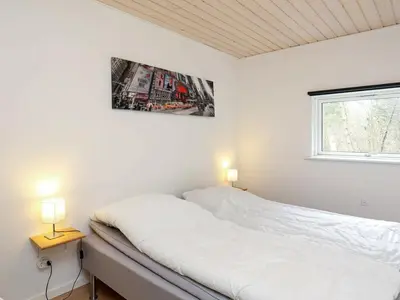 a white bedroom with a bed and two lamps at 10 person holiday home in Løgstør-By Traum in Trend