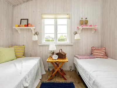 two beds in a room with a table and a window at 6 person holiday home in Blokhus-By Traum in Blokhus