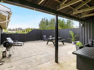 a patio with a grill and a picnic table at 6 person holiday home in Blokhus-By Traum in Blokhus