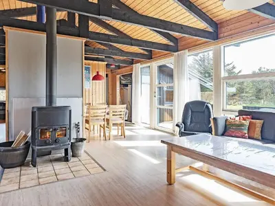 a living room with a wood stove and a table at 8 person holiday home in Vestervig in Vestervig