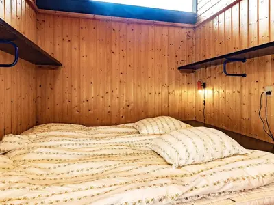 a large bed in a room with wooden walls at 8 person holiday home in Vestervig in Vestervig