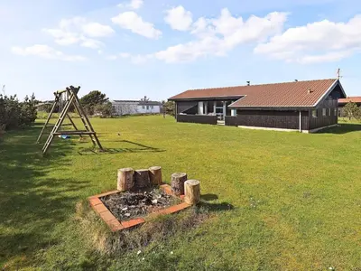 a yard with a swing set and a playground at 8 person holiday home in Vestervig in Vestervig
