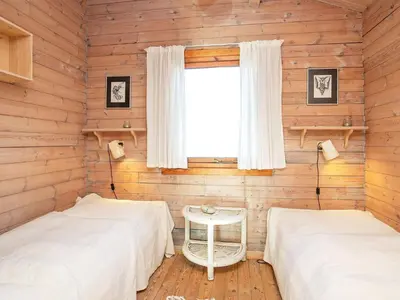 two beds in a room with wooden walls at Seaside Fun & Relaxation-By Traum in Harboør