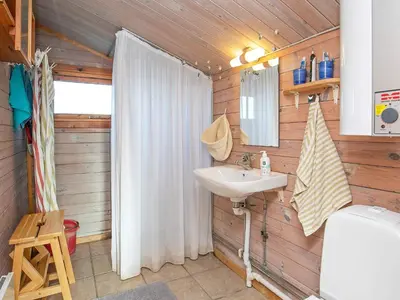 a bathroom with a sink and a shower curtain at Seaside Fun & Relaxation-By Traum in Harboør