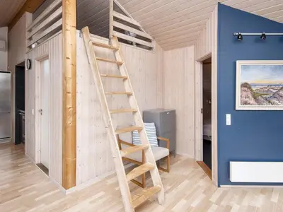 a wooden ladder in a room with a blue wall at 10 person holiday home in Harboøre-By Traum in Harboør