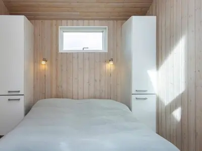 a bedroom with a bed and two white cabinets at 10 person holiday home in Harboøre-By Traum in Harboør