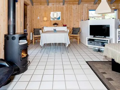 a living room with a fireplace and a table at Secluded Haven in Thorup - By Traum Ferienwohnungen in Torup Strand