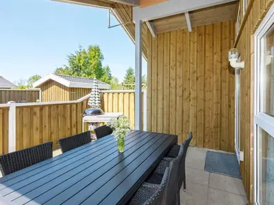 a patio with a wooden table and chairs at Secluded Haven in Thorup - By Traum Ferienwohnungen in Torup Strand