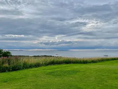 a grassy field with a view of a body of water at 6 person holiday home in Vinderup-By Traum in Vinderup