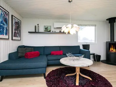 a living room with a blue couch and a table at 6 person holiday home in Vinderup-By Traum in Vinderup