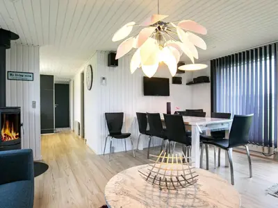 a dining room with a table and chairs and a chandelier at 6 person holiday home in Vinderup-By Traum in Vinderup