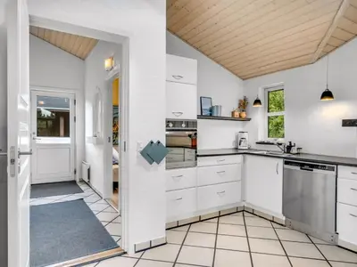 a kitchen with white cabinets and a wooden ceiling at Holiday Home Yngve - 3-5km from the sea by Interhome in Fjerritslev