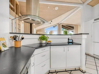 a kitchen with white cabinets and a wood ceiling at Holiday Home Yngve - 3-5km from the sea by Interhome in Fjerritslev