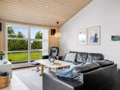 a living room with a leather couch and a table at Holiday Home Yngve - 3-5km from the sea by Interhome in Fjerritslev