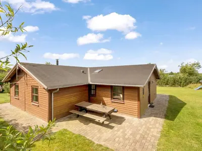 a log cabin with a picnic bench in a yard at Holiday Home Yngve - 3-5km from the sea by Interhome in Fjerritslev