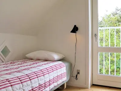 a bedroom with a bed and a lamp next to a window at 5 person holiday home in Harboøre in Harboør