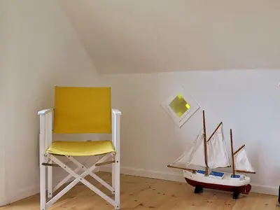 a yellow chair and toy boats in a room at 5 person holiday home in Harboøre in Harboør