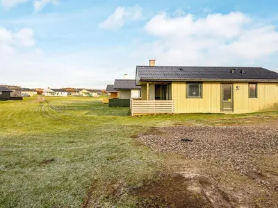 a yellow house in a field with a yard at 6 person holiday home in Lemvig-By Traum in Trans