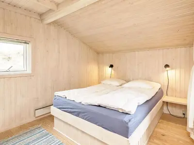 a bedroom with a bed in a small room at 8 person holiday home in Pandrup-By Traum in Blokhus