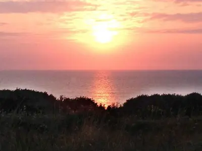 a sunset over the ocean with the sun in the sky at 4 person holiday home in Lemvig-By Traum in Trans