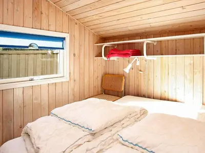a room with two beds in a room with a window at 6 person holiday home in Blokhus-By Traum in Blokhus