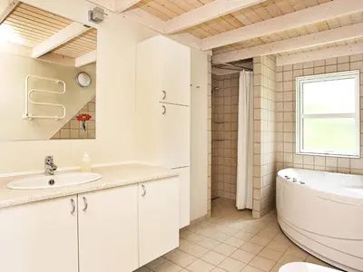a white bathroom with a tub and a sink at 10 person holiday home in Fjerritslev-By Traum in Torup Strand